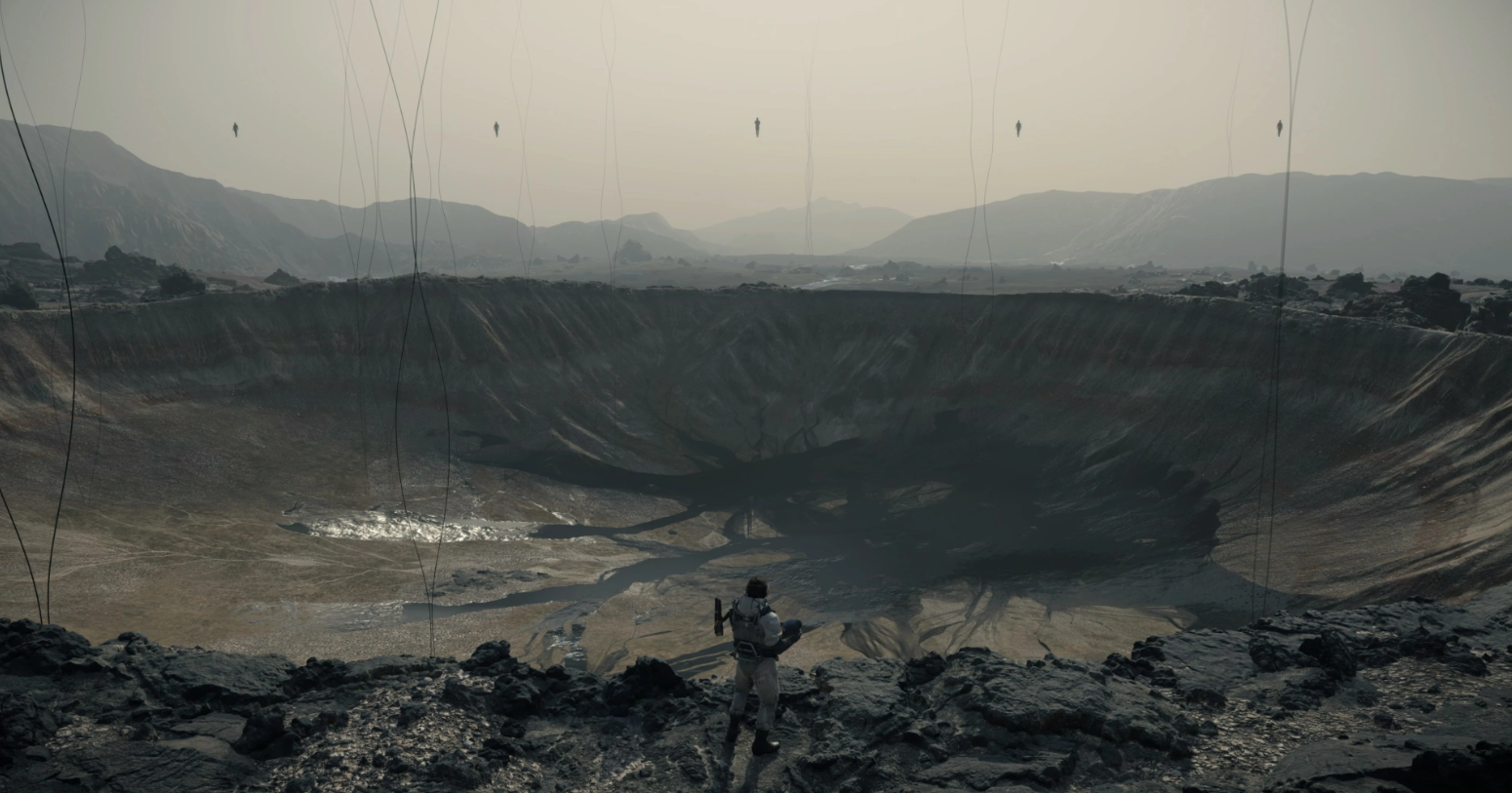 A dramatic image from Death Stranding showing a massive, circular crater left by a Voidout, with remnants of a city around the edges and a sense of desolation, illustrating the destructive power of the phenomenon.